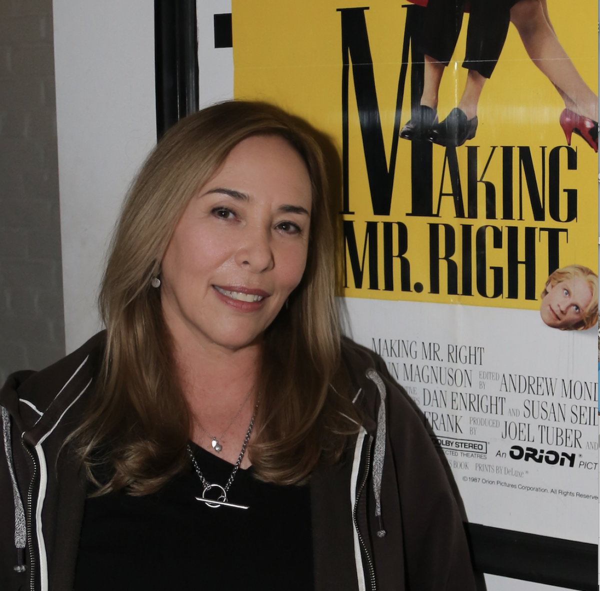 Susan Seidelman smiles next to a poster of "Making Mr. Right."