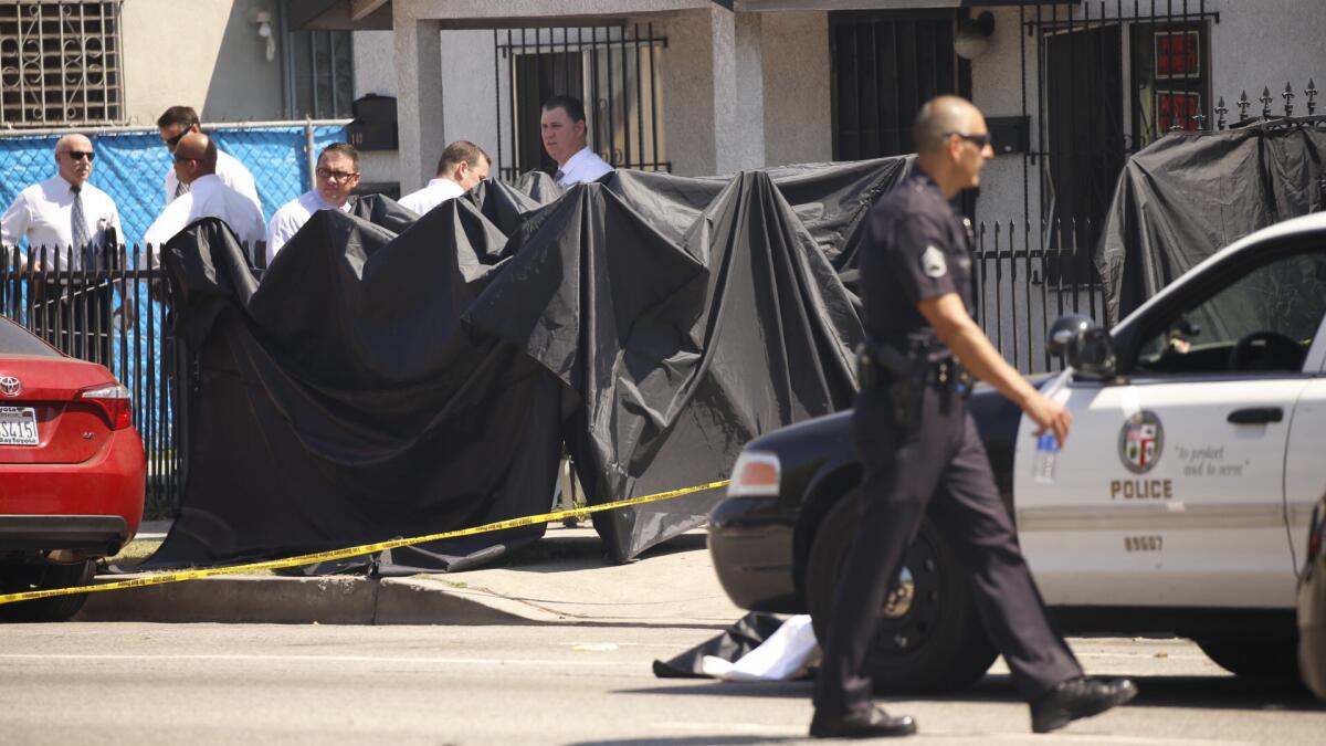 Investigators at the scene where two people were fatally shot in South Los Angeles.