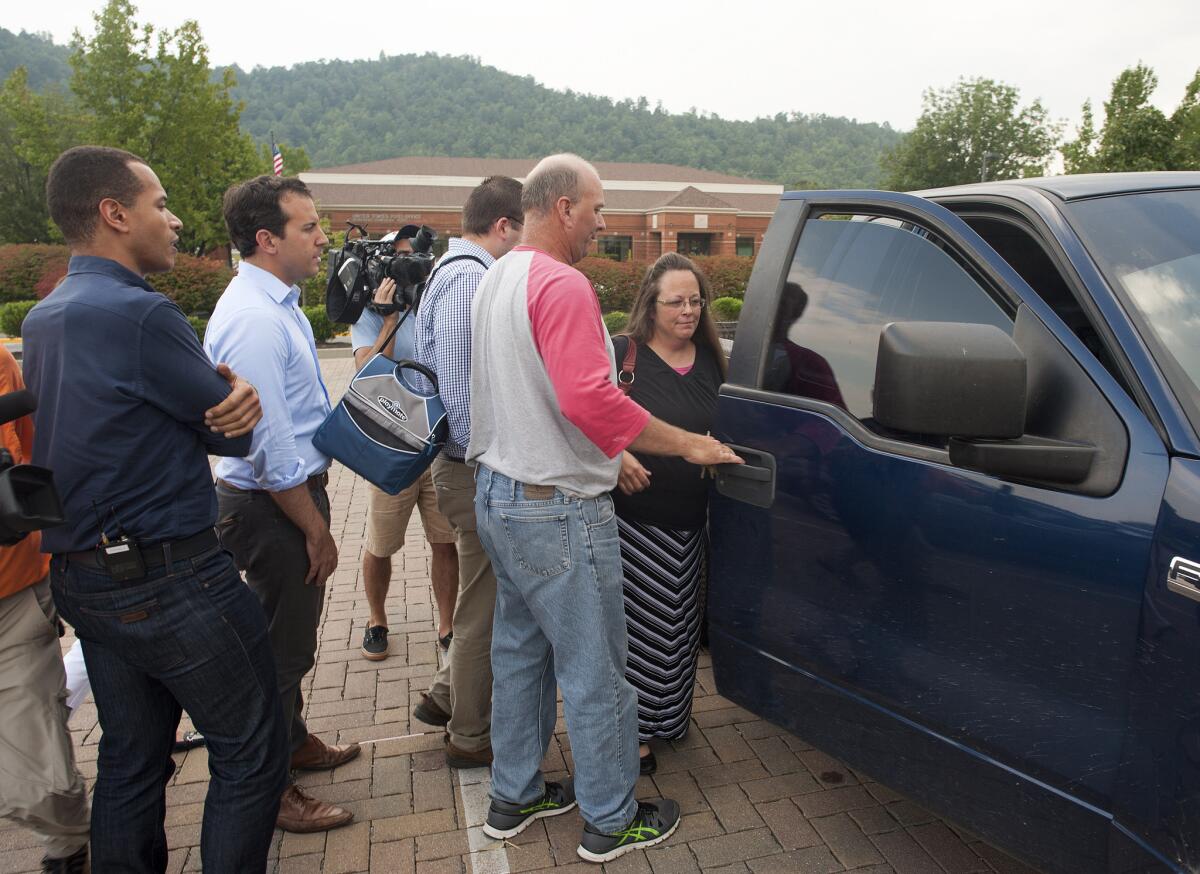 Members of the media follow Rowan County, Ky., Clerk Kim Davis as she is escorted to her vehicle at the Rowan County Courthouse in Morehead, Ky.
