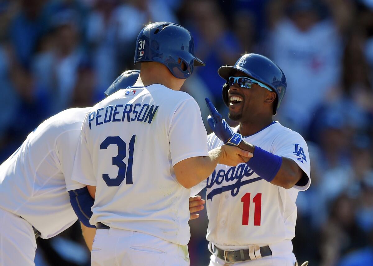 Los Angeles Dodgers' Jimmy Rollins, right, is congratulated by Joc Pederson, center, and Andre Ethier after hitting a three-run home run during the eighth inning of the opening day baseball game in Los Angeles.