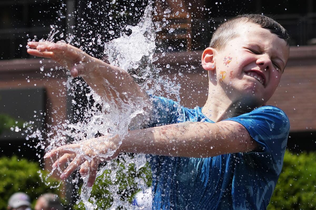 Un niño se refresca junto a una fuente junto al Wrigley Field antes de un juego de béisbol 
