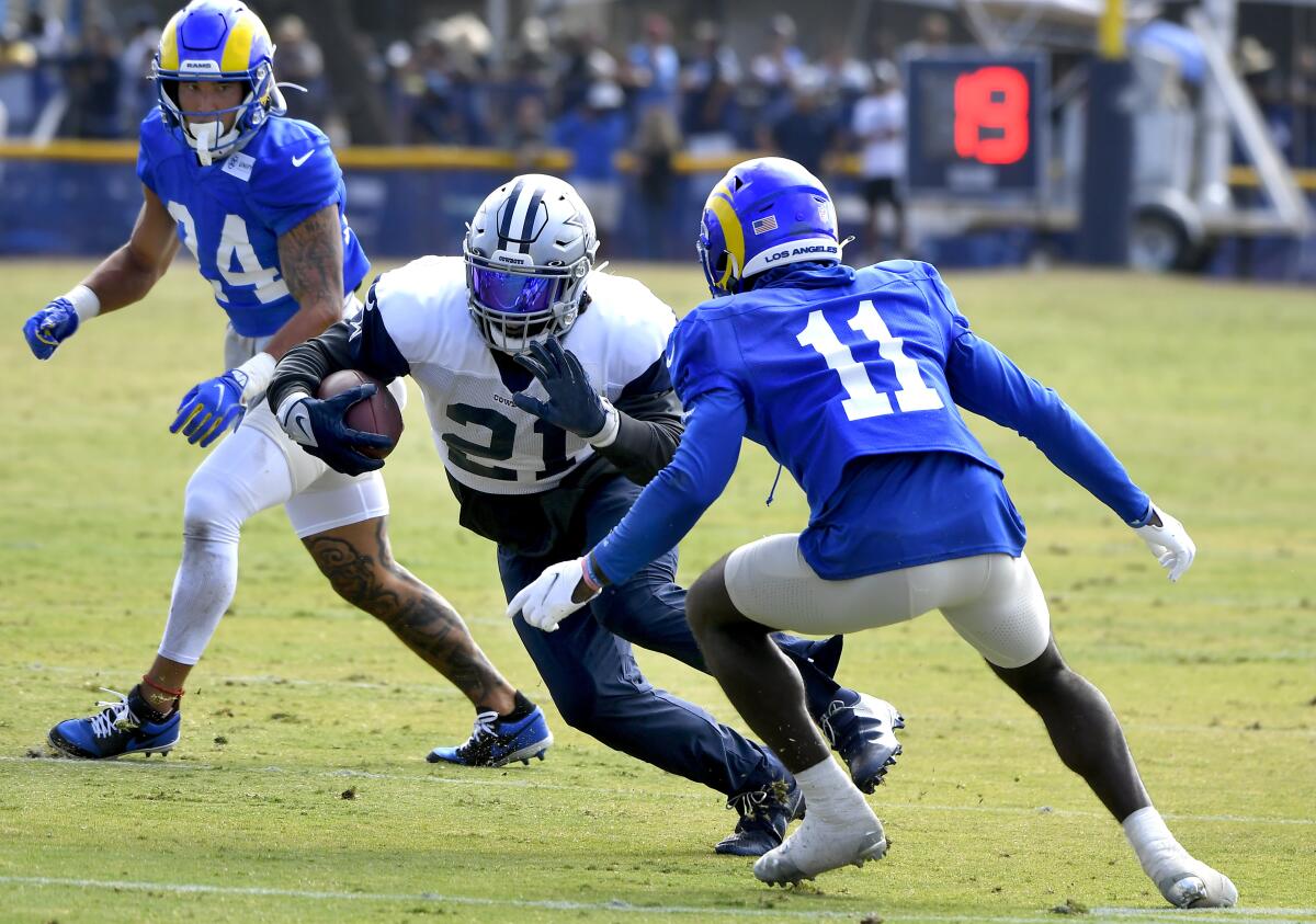 Rams safety Taylor Rapp, left, looks on as Darious Williams closes in on Cowboys running back Ezekiel Elliott on Aug 7, 2021.