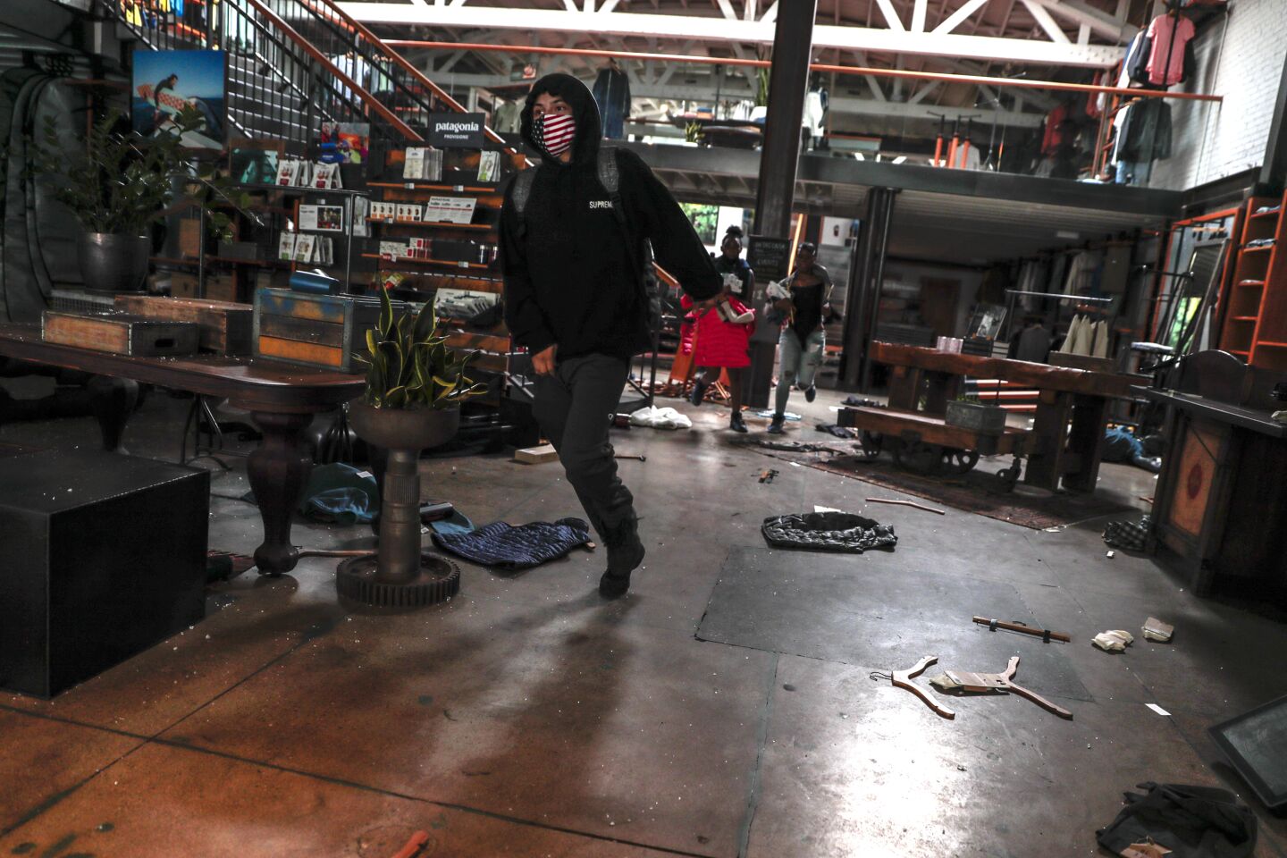 A person rushes out of a looted store in Santa Monica