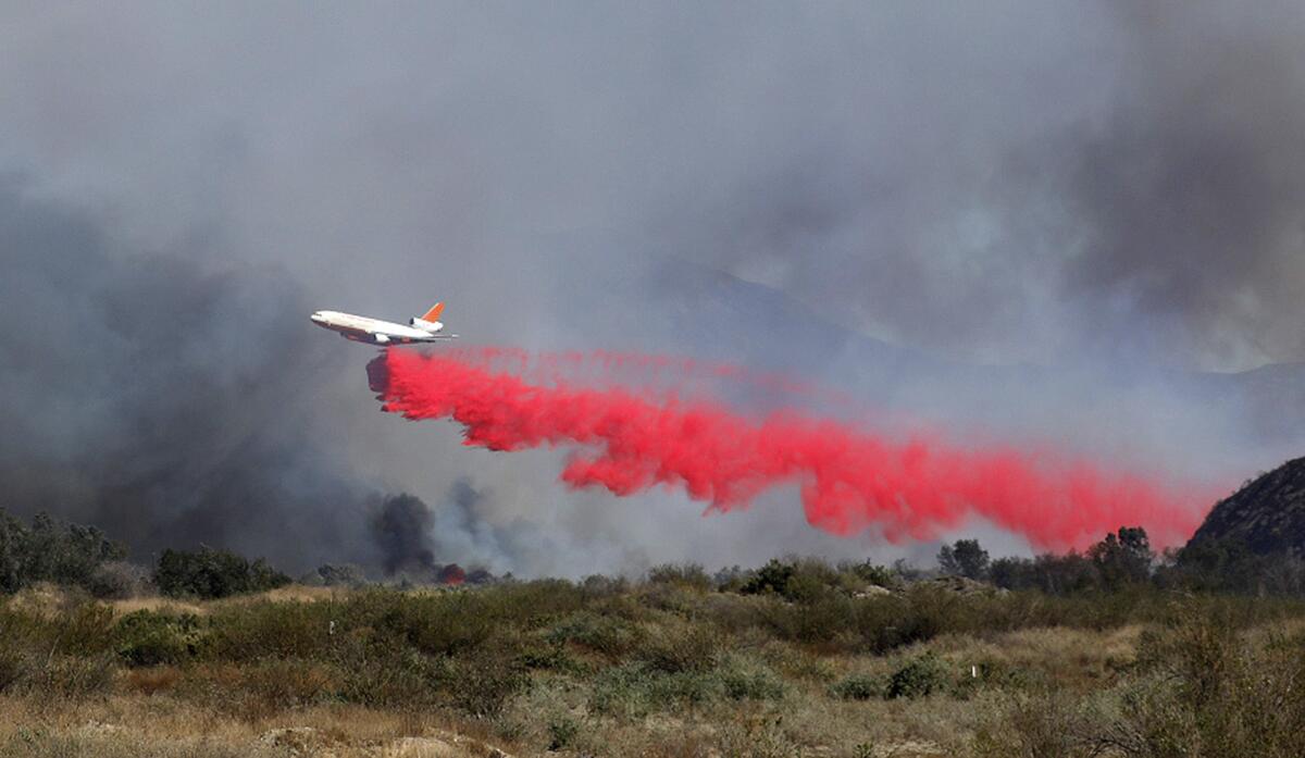 A plane drops fire retardant on the Maria fire between Santa Paula and Saticoy on Friday.