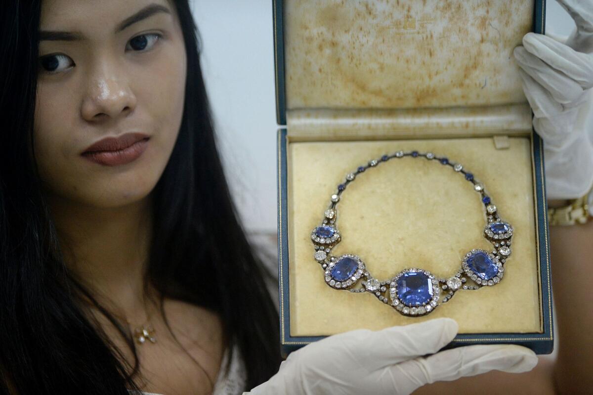 A November 2015 photo shows an official from the Presidential Commission on Good Government (PCGG) holding a piece of jewelry seized by the Philippine government from former first lady Imelda Marcos, at the Central Bank headquarters in Manila.
