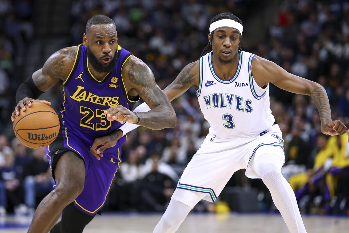 Lakers star LeBron James, left, drives toward the basket in front of Minnesota Timberwolves forward Jaden McDaniels.