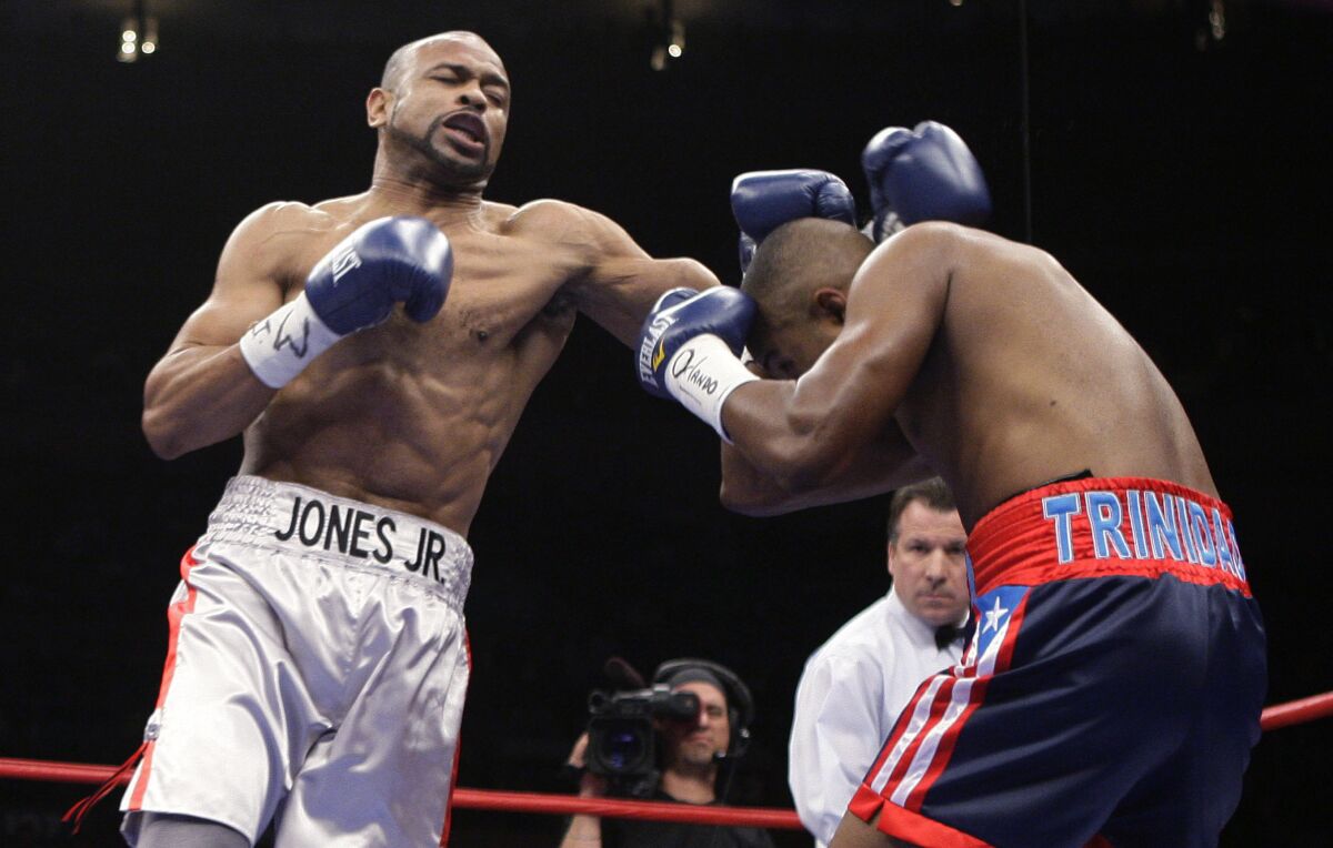 FILE - Roy Jones Jr., left, lands a punch against Felix Trinidad during light heavyweight boxing bout Jan. 19, 2008, at Madison Square Garden in New York. Jones Jr., Miguel Cotto and James Toney have been elected to the International Boxing Hall of Fame along with three-division female champions Regina Halmich and Holly Holm. (AP Photo/Julie Jacobson, File)