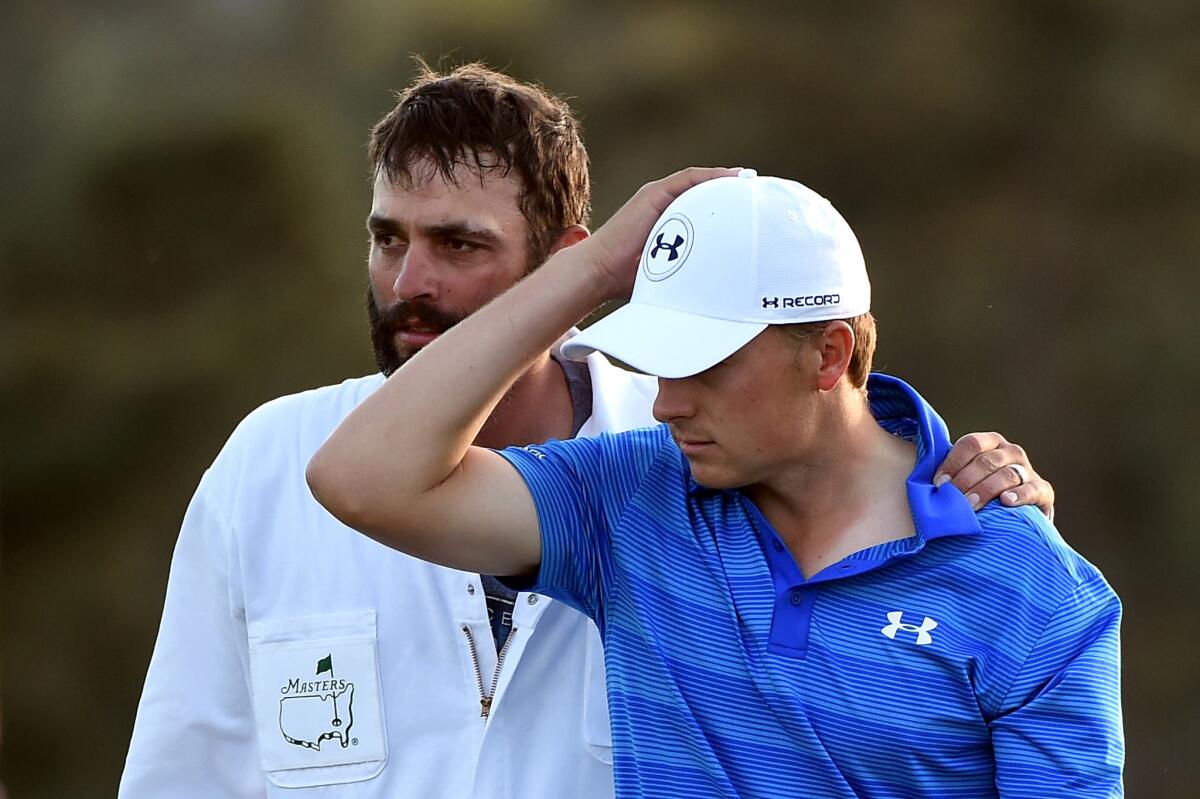 Jordan Spieth gets a pat on the back from caddie Michael Greller on the 18th hole after finishing second at the Masters.