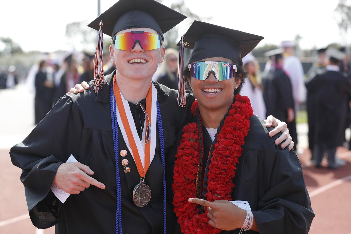Proud graduates Davis Van Dyke and Nathan McCall, from left, walk into Tuesday's ceremony.