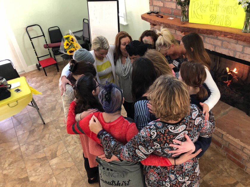 Women form a group hug at a 2018 event for rape survivors hosted by Sunlight Retreats.
