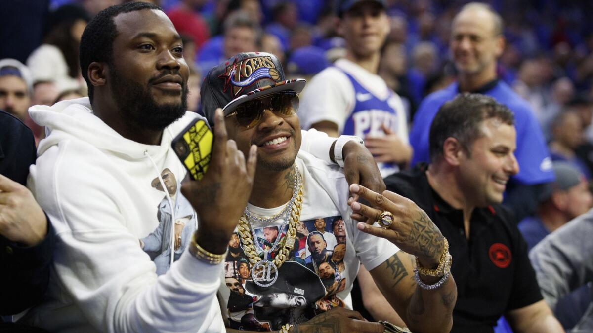 Allen Iverson, right, poses with rapper Meek Mill, left, during the first half of Game 3 of a second-round NBA playoff series between the Philadelphia 76ers and Toronto Raptors on Thursday in Philadelphia.