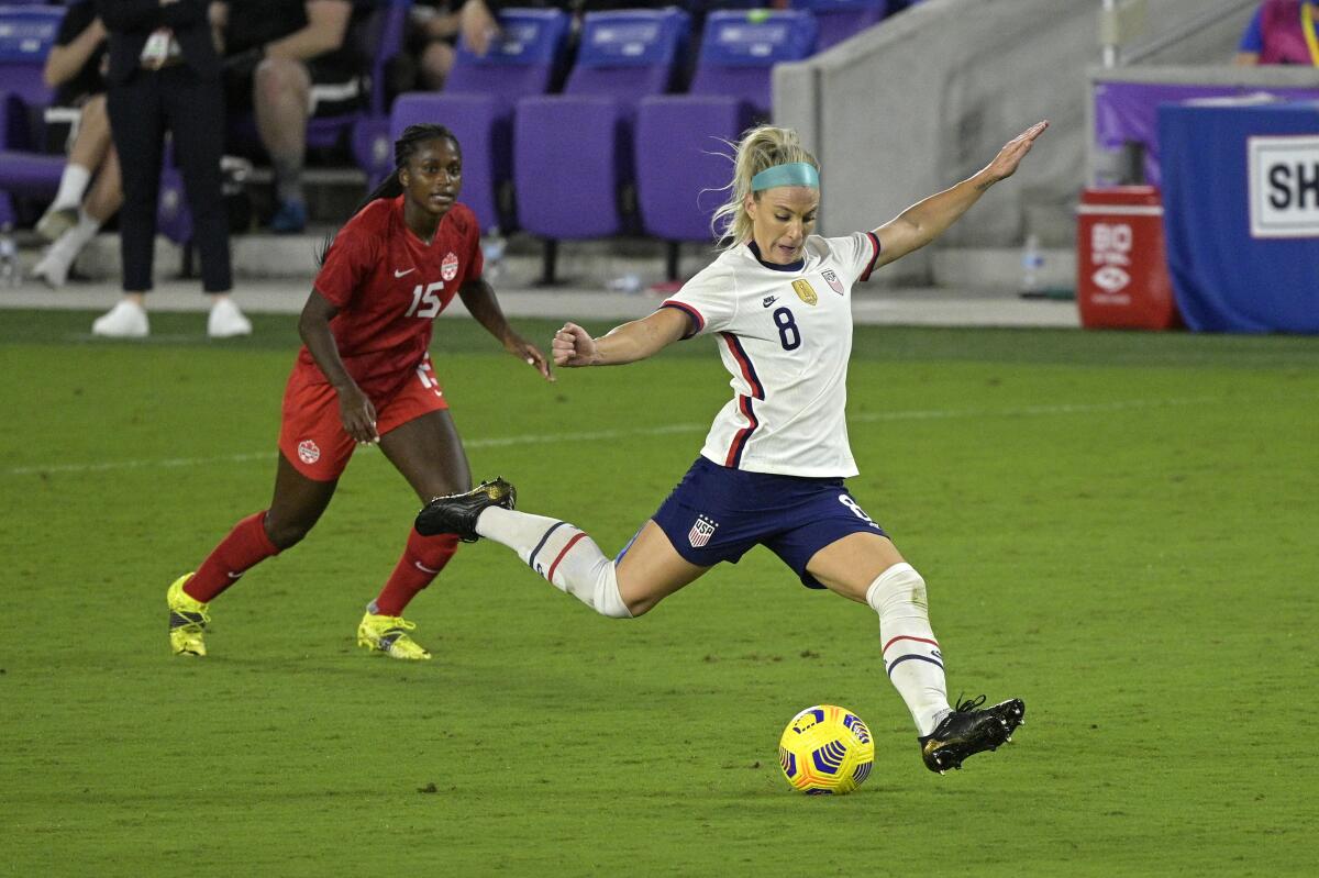 U.S. midfielder Julie Ertz kicks a ball in front of Canada forward Nichelle Prince.