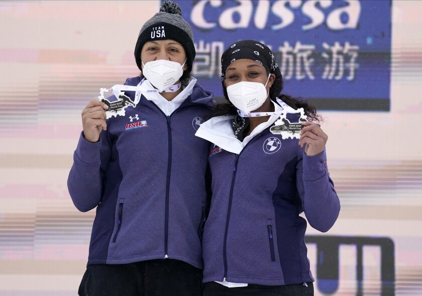 Winners Elana Meyers Taylor and Lake Kwaza of the United States show their medals during award ceremony of the two-woman Bobsleigh World Cup race in Sigulda, Latvia, Sunday, Jan. 2, 2022. (AP Photo/Roman Koksarov)