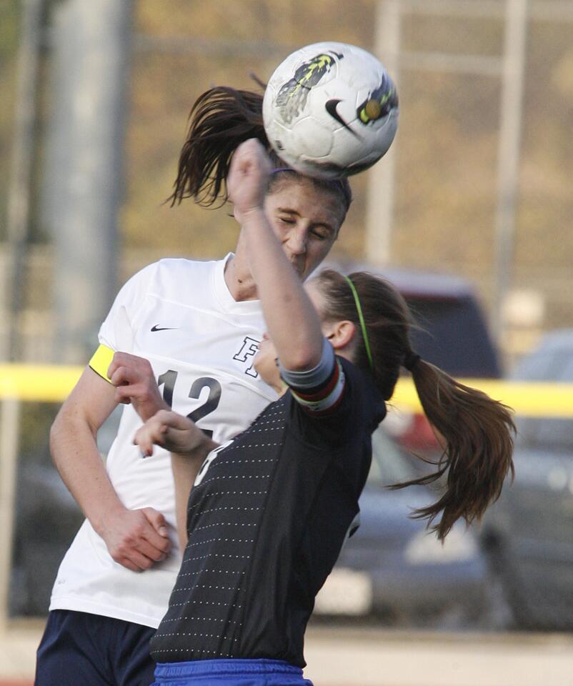 Flintridge Prep's Whitney Cohen heads the ball over San Marino's Hope Welder in a non-league girls soccer match at the Glendale Sports Complex in Glendale on Thursday, December 6, 2012.