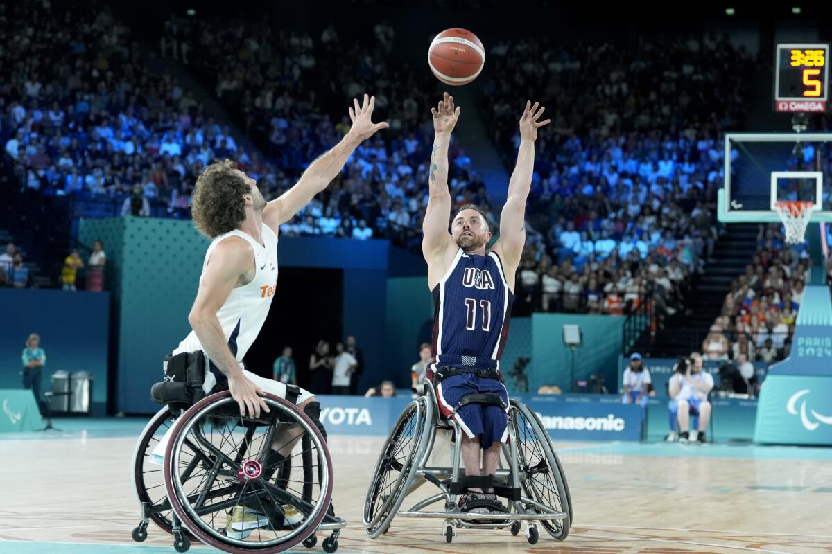 American Steve Serio shoots over an opponent's outstretched hand during a wheelchair basketball game at the Paralympics