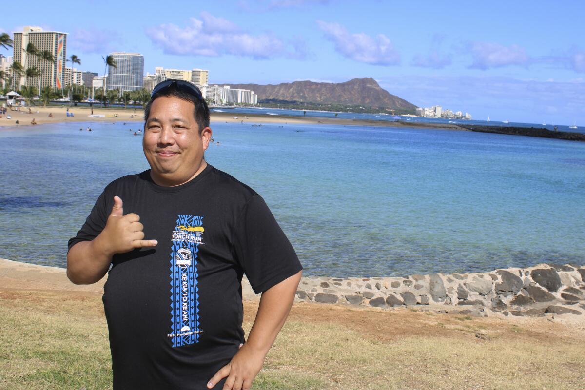 Todd Yukutake, a director of the Hawaii Firearms Coalition, stops to pose in front of Diamond Head