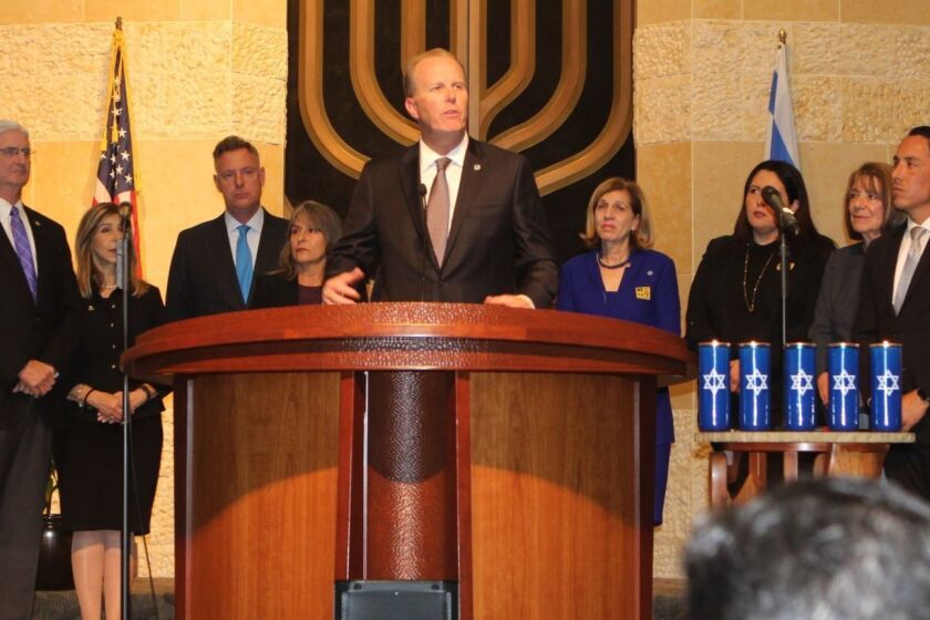 TextEditor San Diego Mayor Kevin Faulconer — flanked by San Diego County Sheriff Bill Gore, County District Attorney Summer Stephan, Congress member Scott Peters, City Council members Lorie Zapf and Barbara Bry, Southwestern Community College trustee Nora Vargas, Congress member Susan Davis, Assembly member Todd Gloria and School Board president Kevin Beiser — addresses an audience of 2,000 grieving members and supporters of the San Diego Jewish community at Temple Beth Israel in University City, Oct. 29.