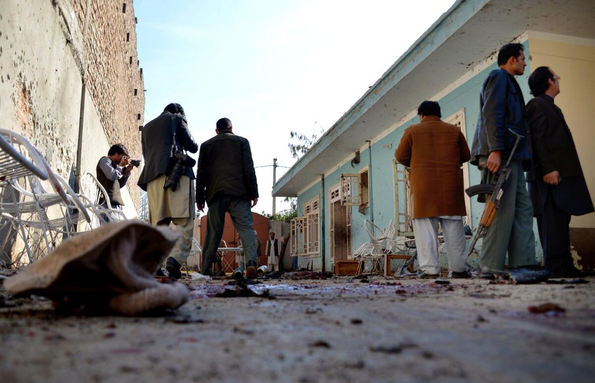 Afghan security forces inspect the site of a suicide attack at a house in Jalalabad, Afghanistan, on Sunday.