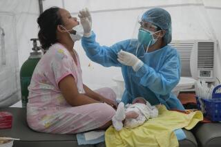 Medical Technologist Erika Alvarado performs a COVID-19 test on a patient who just delivered a baby outside a hospital in Manila, Philippines on Friday, Dec. 24, 2021. In the Philippines, one of the worst-hit by the pandemic in Southeast Asia, daily COVID-19 infections have considerably dropped from an average 22,000 cases just three months ago during an alarming spike set off by the delta variant to just a few hundred in recent days after a delayed vaccination campaign considerably intensified with more vaccine shipment deliveries. (AP Photo/Aaron Favila)