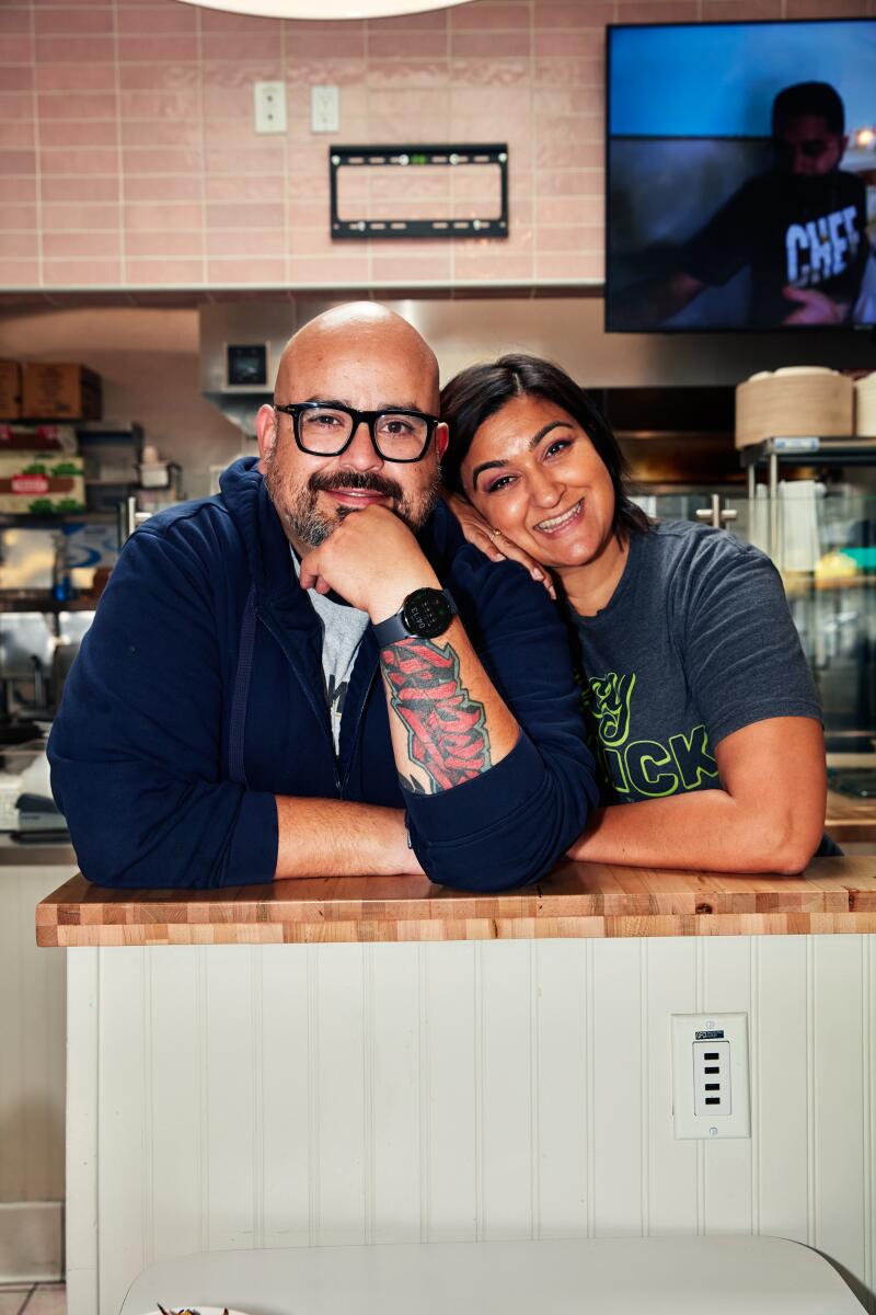 Marcel Rene Michel and Rhea Patel Michel stand together, leaning on a counter.