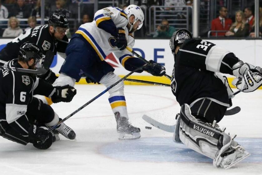 Kings goalie Jonathan Quick (32) deflects a shot as the puck bounces away from Blues center Patrik Berglund (21) with defenseman Jake Muzzin (6) and right wing Marian Gaborik (12) defending during the first period on Mar. 13.