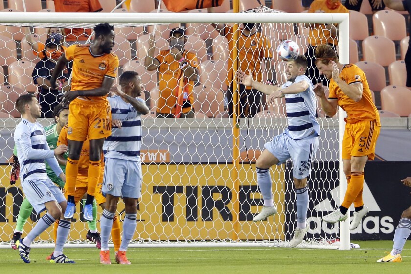 Sporting Kansas City defender Andreu Fontas (3) blocks the shot on goal in front of Houston Dynamo defender Tim Parker (5) on the attempt by midfielder Derrick Jones (21) during the first half of an MLS soccer match Wednesday, May 12, 2021, in Houston. (AP Photo/Michael Wyke)