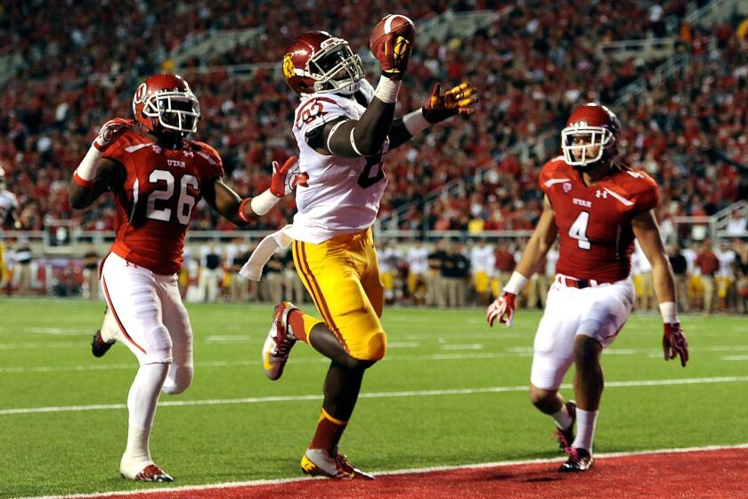 USC tight end Randall Telfer makes a one-handed catch for a touchdown in front of Utah defenders Ryan Lacy and Brian Blechen during a game last season.