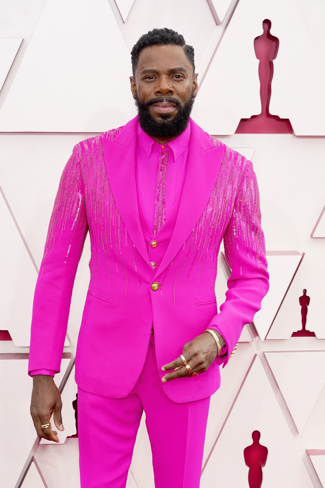 Colman Domingo arrives at the Oscars in a bright dark pink suit and shirt.