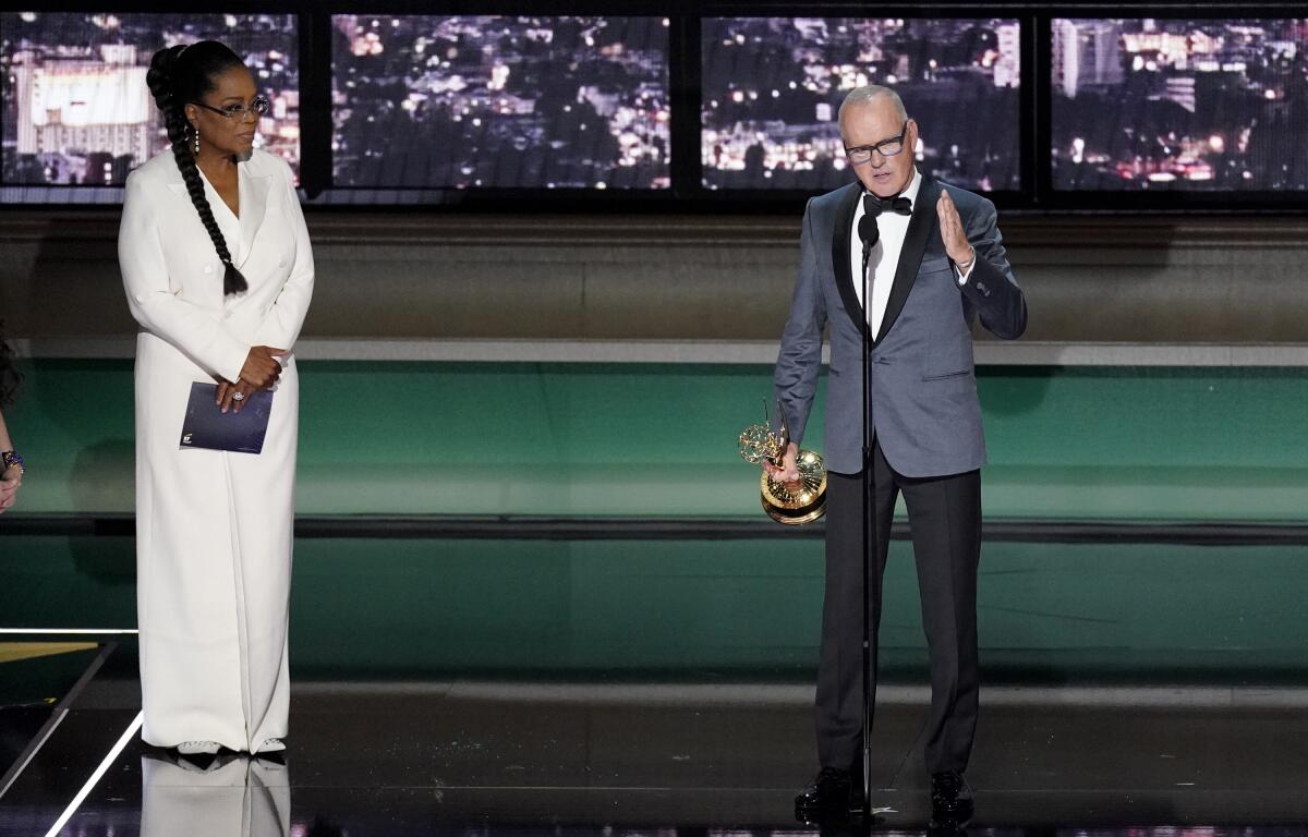 Michael Keaton, derecha, recibe el Emmy a mejor actor en una serie limitada, antología 
