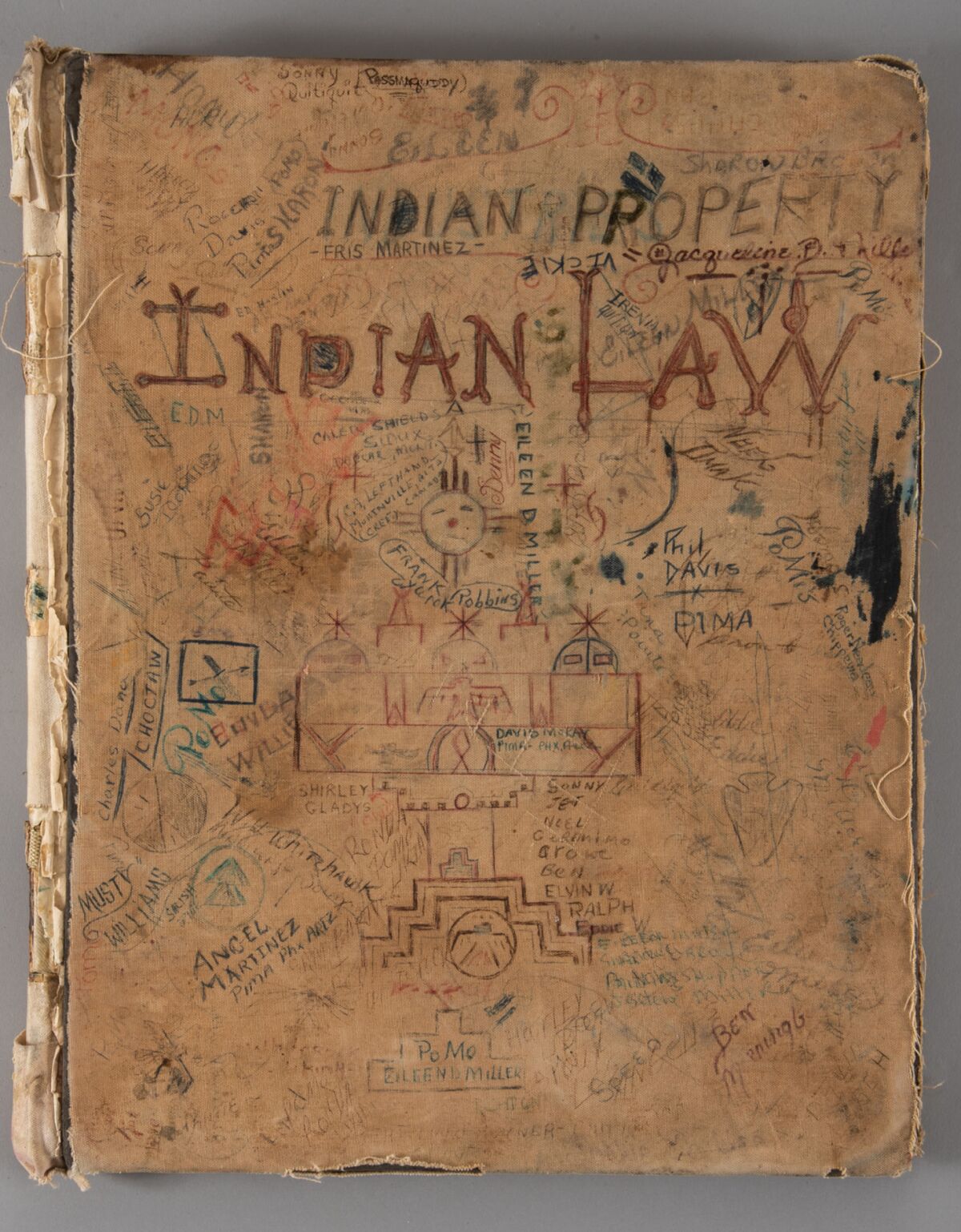The cover of the Alcatraz Log Book features names and drawings and the words "INDIAN LAW" in capital letters in red ink.