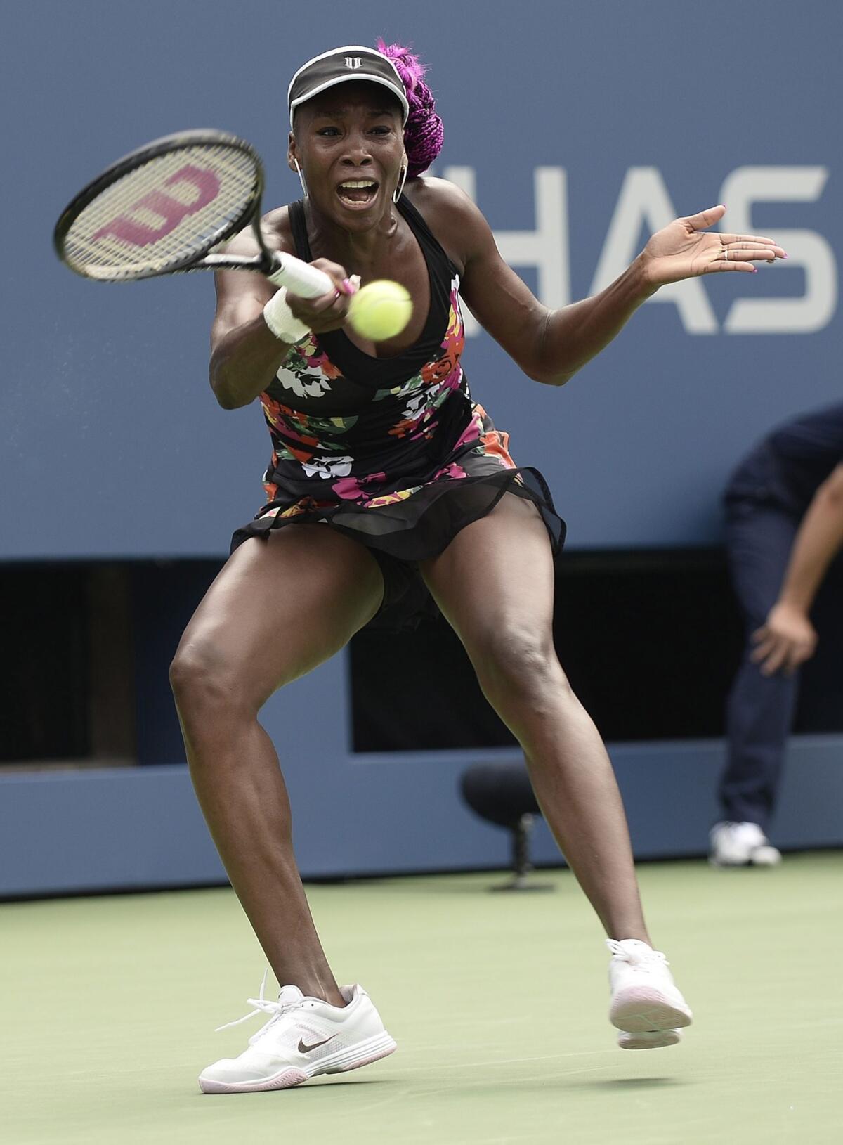 Venus Williams returns a shot during her first-round victory over Kirsten Flipkens at the U.S. Open on Monday.