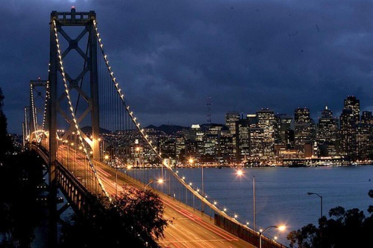 A few evening commuters make their way across the Bay Bridge as a storm passes behind the San Francisco skyline, as seen from Yerba Buena Island.