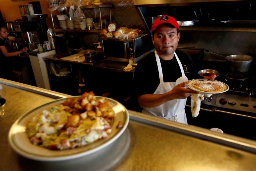 LOS ANGELES, CALIF. -- TUESDAY, JUNE 27, 2017: Jesus Matias, an employee for nine years, prepares dishes at Nickel Diner in Los Angeles, Calif., on June 27, 2017. The owners of the Nickel Cafe in DTLA say that a $12 minimum wage will kill them, and restaurants like theirs. That is, places where regular people can afford to eat, and get served by attentive waiters, and meet the chef, and eat good food. (Gary Coronado / Los Angeles Times)