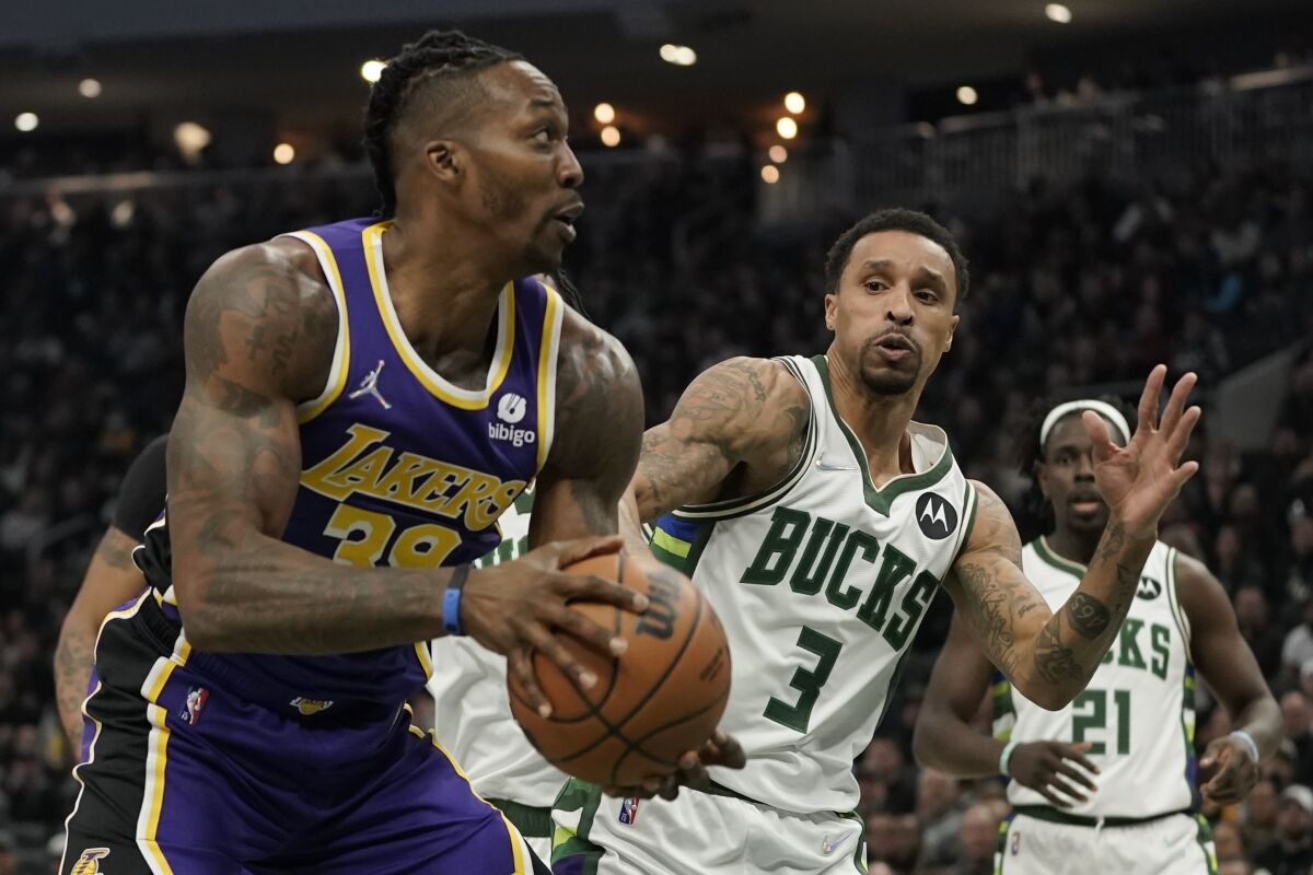 Lakers' Dwight Howard is fouled as he tries to shoot past Milwaukee Bucks' George Hill.
