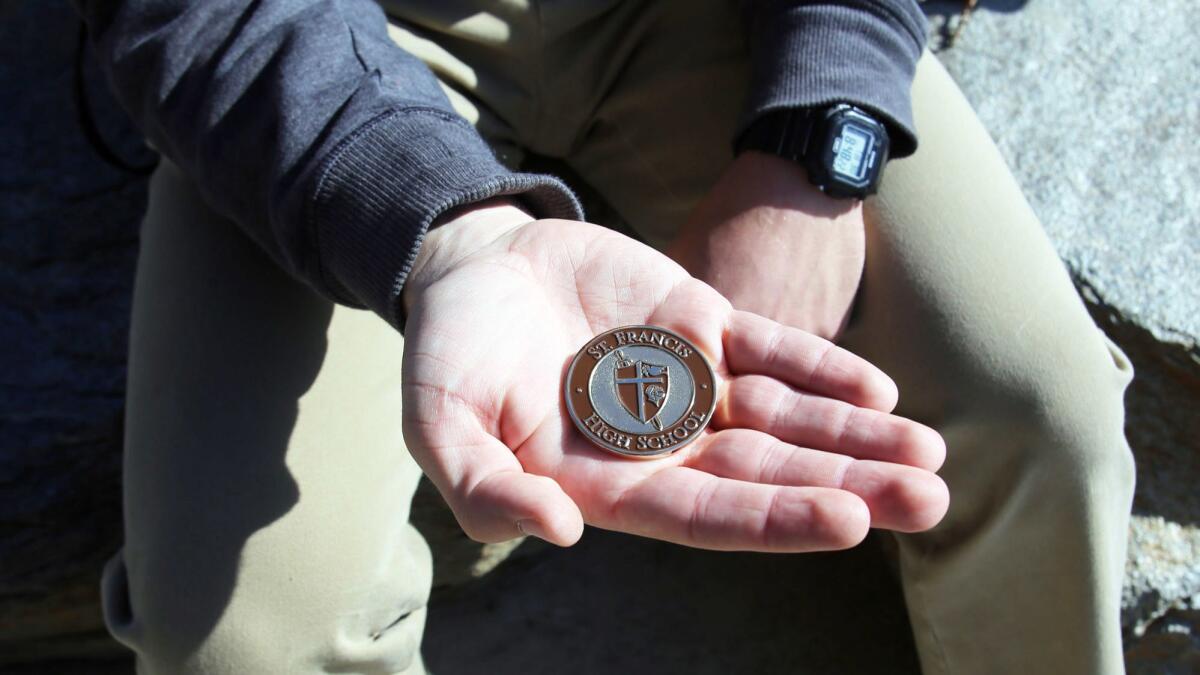 St. Francis High School junor Danny Bozanic holds a SFHS President's Coin he received for exemplifying Franciscan virtues in tangible ways both on and off campus. His coin is the very first to be given to a student by school President Fr. Tony Marti.