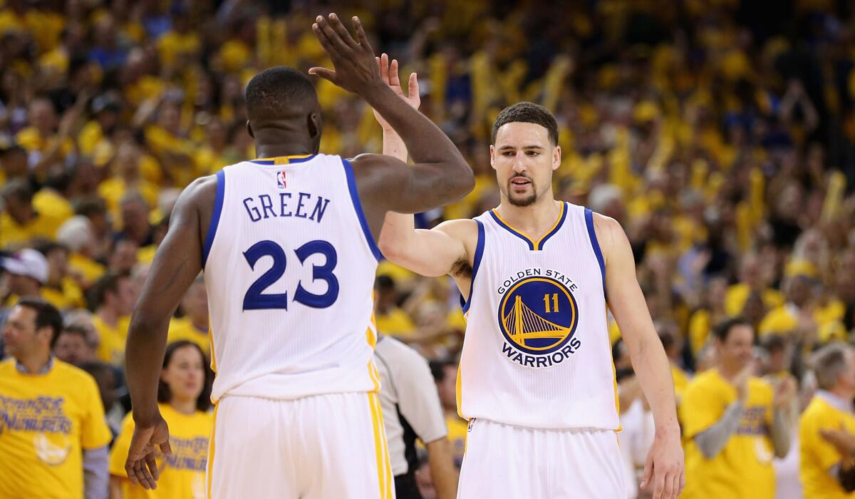 Golden State Warriors' Klay Thompson, right, and Draymond Green celebrate in the final minute of their victory over the Portland Trail Blazers in Game 2 of the Western Conference Semifinals on Tuesday.