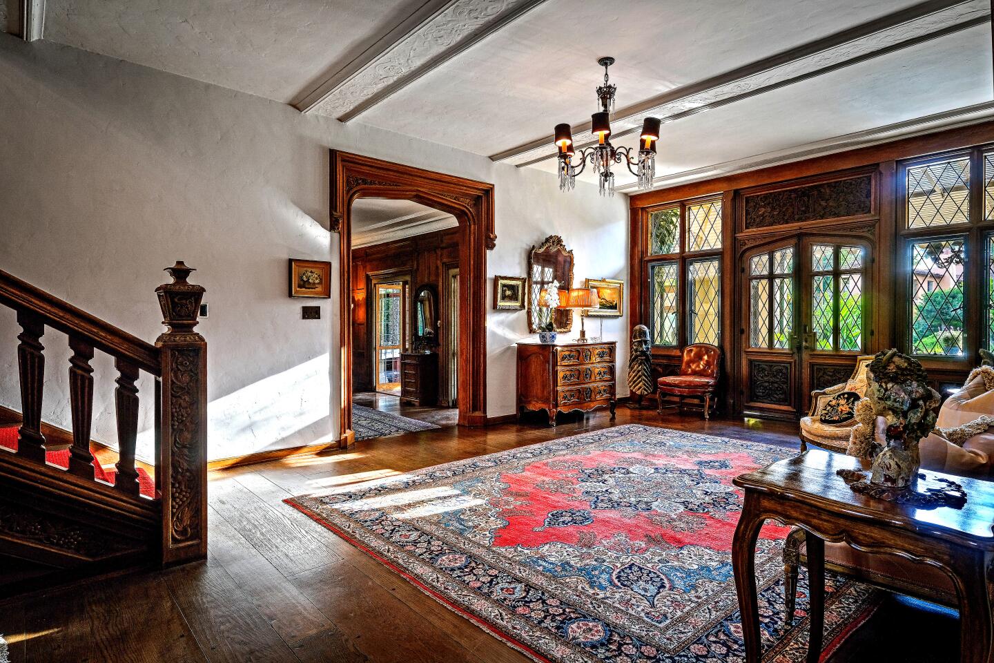 A rug adorns the entryway to the home, with hardwood floors and a staircase