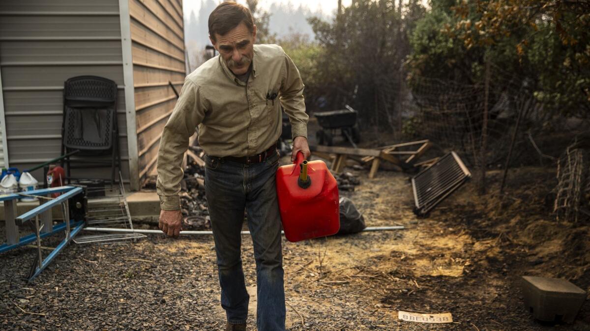 Jeff Evans carries a container of gasoline he found at a Concow property Friday.