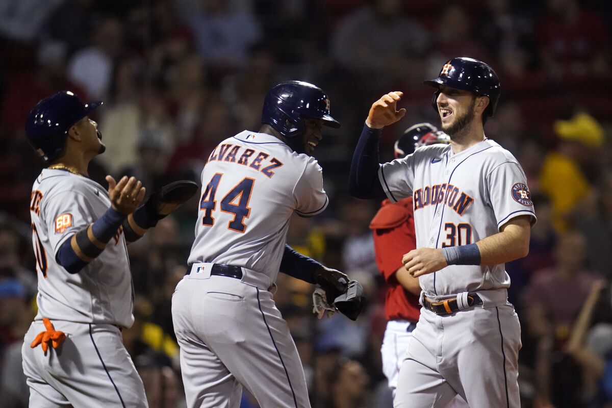 Houston Astros' Kyle Tucker (30) is congratulated by Yordan Alvarez (44) and Yuli Gurriel, left, after his grand slam during the fourth inning of the team's baseball game against the Boston Red Sox at Fenway Park, Tuesday, May 17, 2022, in Boston. (AP Photo/Charles Krupa)