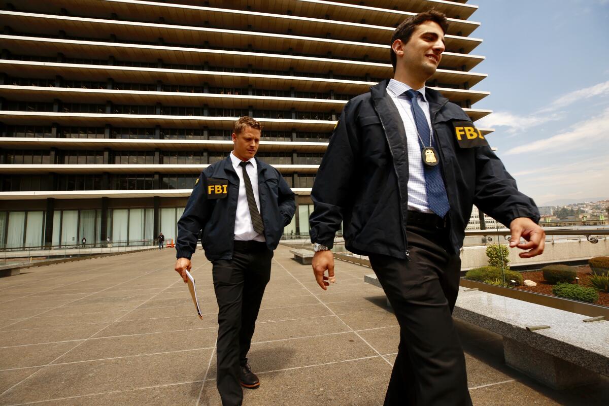 FBI agents leave the downtown headquarters of the Los Angeles Department of Water and Power after serving a search warrant Monday.