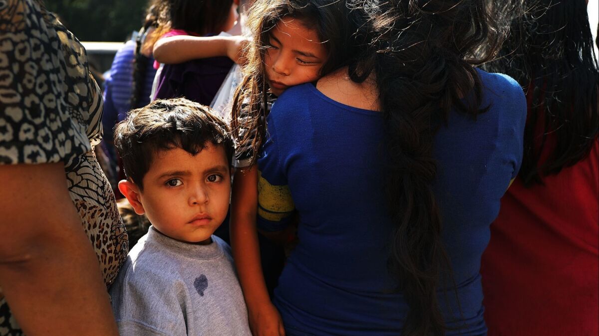Dozens of women, men and their children, many fleeing poverty and violence in Honduras, Guatamala and El Salvador, arrive at a bus station following release from Customs and Border Protection in McAllen, Texas.