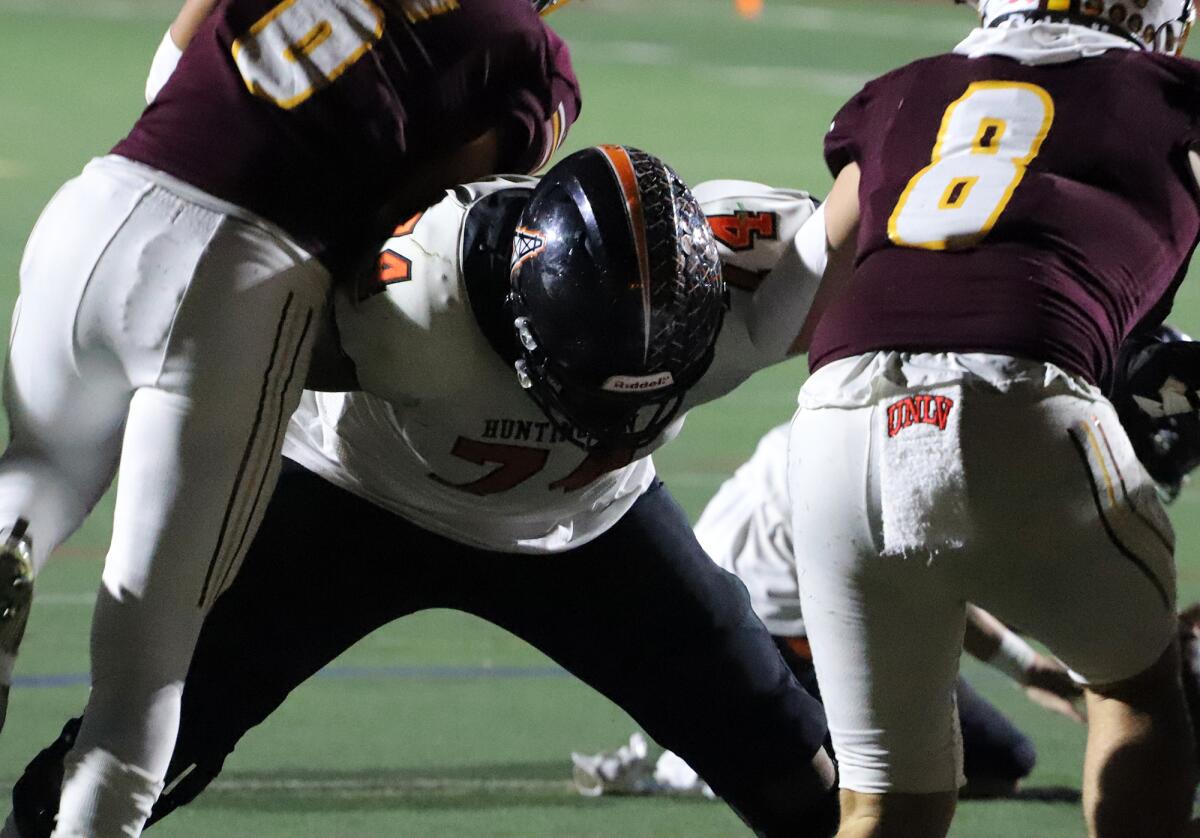 Huntington Beach's Justin Tauanuu (74) blocks Simi Valley defenders in the semifinals of the CIF Division 6 playoffs.