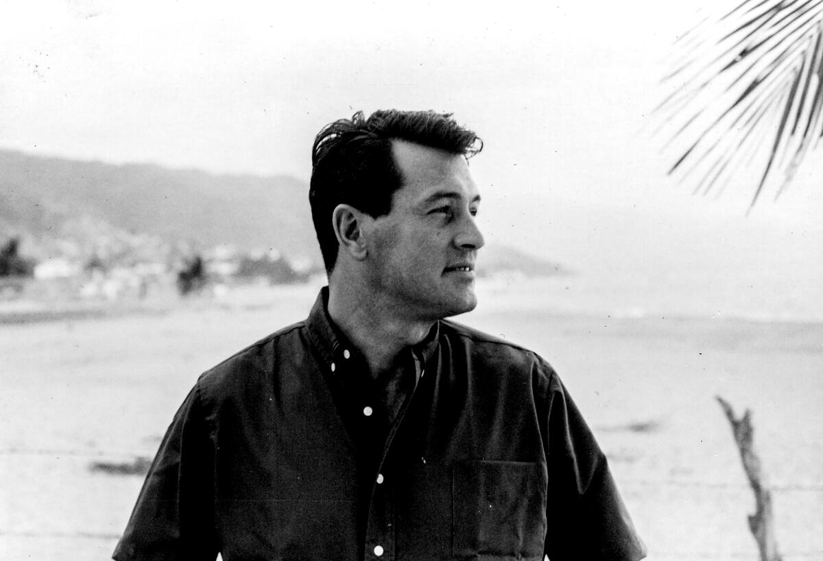 A man looks into the distance, with the beach in the background.