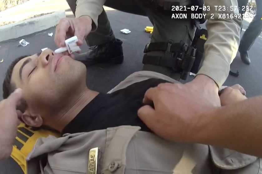 San Diego County Sheriff's Deputy David Faiivae gets aid from his Field Training Officer, Corporal Scott Crane, after being exposed to Fentanyl on July 3, 2021.