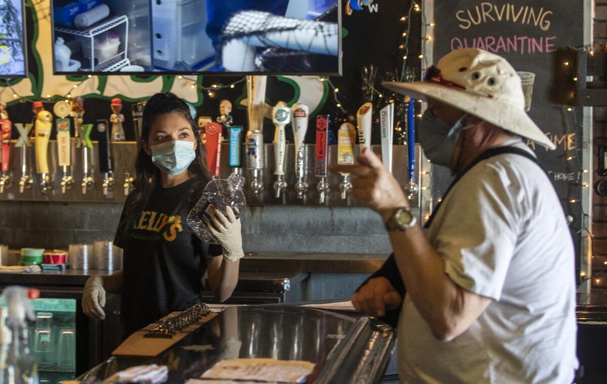 Bartender Brianna Van De Mortel takes an order from a customer at Kelly's Korner in Placentia in May. 