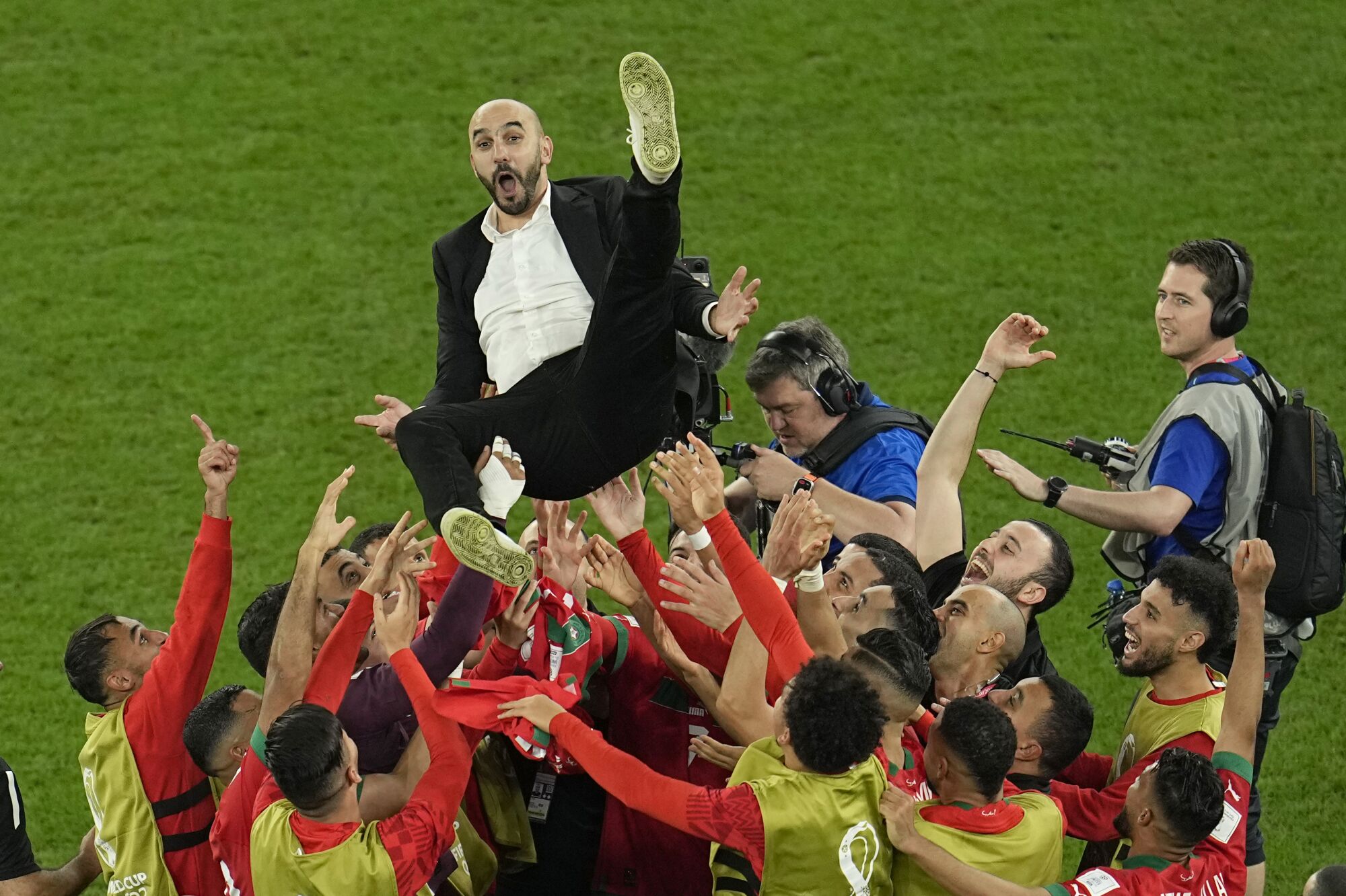 Moroccan coach Walid Regragui is thrown into the air by players celebrating the team's historic World Cup victory over Spain
