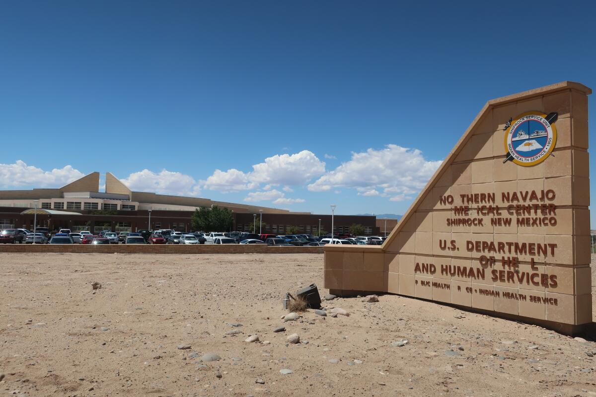 A sign outside a desert building, with missing letters, is supposed to say, 'Northern Navajo Medical Center'