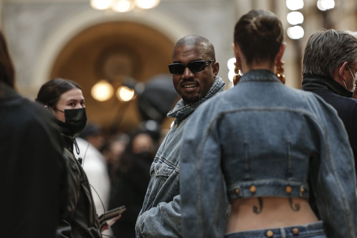Kanye West peeks out amid other people