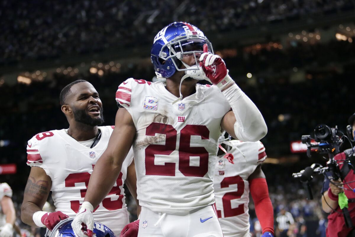 New York Giants running back Saquon Barkley (26) celebrates his touchdown in overtime to defeat the New Orleans Saints in an NFL football game in New Orleans, Sunday, Oct. 3, 2021. The Giants won 27-21.(AP Photo/Brett Duke)