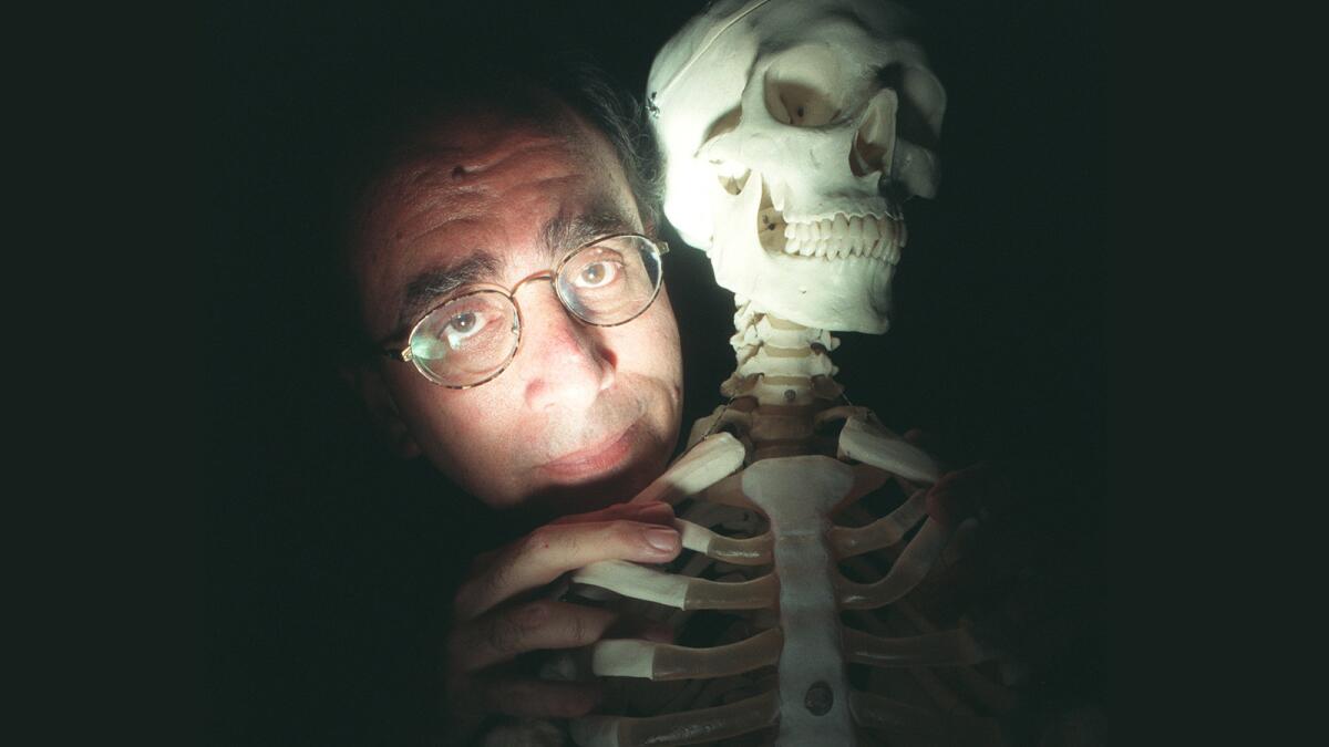 R.L. Stine poses with an inspirational prop, a skeleton which stands in the office where he writes.